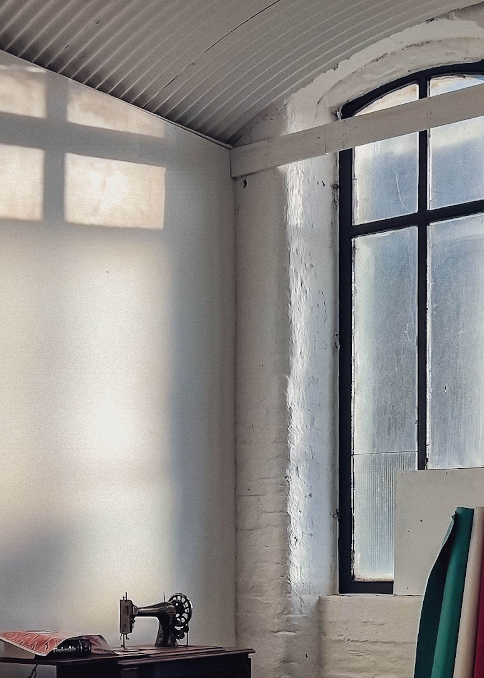 Light through the arched mill windows onto whitewashed brick